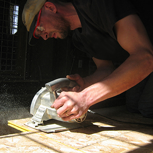 Man Cutting Plywood with a Circular Saw